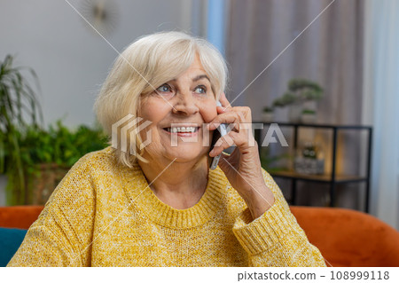 Happy senior old woman involved in pleasant conversation phone call good news enjoy talking gossip Happy senior old woman involved in pleasant conversation phone call good news enjoy talking gossip 108999118