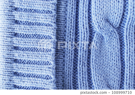 Texture, background, pattern. The woolen fabric is knitted with knitting needles in pastel shades of blue. 108999710