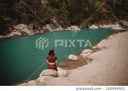 Woman enjoying tranquility on the background of a lake in Turkey. 108999981