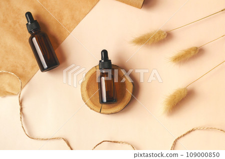 Hand making DIY scene. Glass amber bottles with black cap flat lay. Beauty products packaging. Dropper bottle with pipette on wooden podium. Natural eco-friendly cosmetics presentation with copy space Hand making DIY scene. Glass amber bottles with black cap flat lay. Beauty products packaging. Dropper bottle with pipette on wooden podium. Natural eco-friendly cosmetics presentation with copy space 109000850