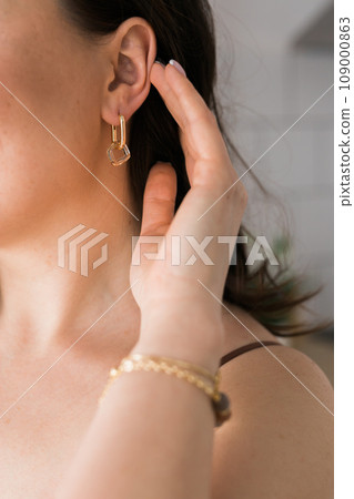 Detail of young woman wearing beautiful luxury earring. Handmade jewellery and accessories 109000863