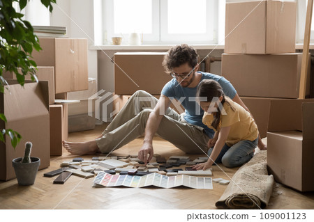 Father and daughter choosing samples for house decoration 109001123