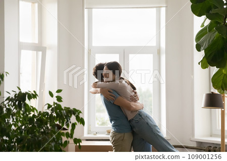 Overjoyed loving young spouses cuddling celebrating relocation day 109001256