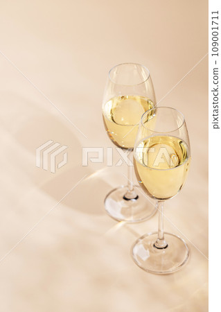 Two champagne glasses on a beige 109001711