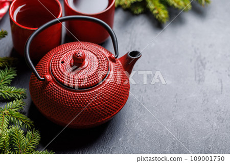 Teapot, cup, and fir tree branches create a cozy scene Teapot, cup, and fir tree branches create a cozy scene 109001750