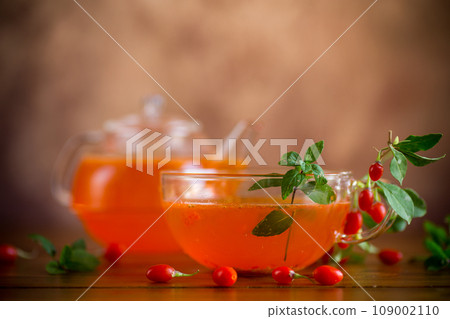 Prepared drink from ripe goji berries in a glass cup and teapot 109002110