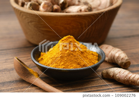 Turmeric spice. Curcuma powder seasoning and whole turmeric roots. 109002276
