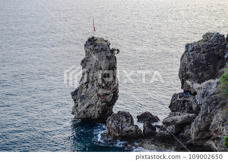 Limestone cliffs by sea. Waves beat on the rocks. 109002650