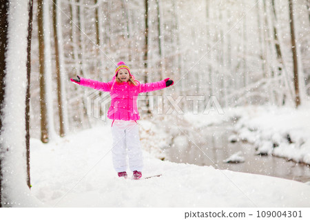 Child playing with snow in winter. Kids outdoors. 109004301