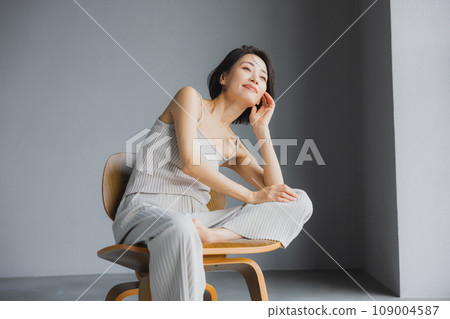Woman sitting on chair Woman sitting on chair 109004587