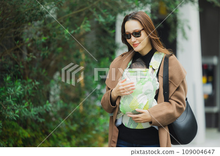 一位母親帶著嬰兒背帶外出 109004647