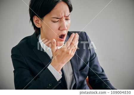 A young male office worker who is sleepy and yawns A young male office worker who is sleepy and yawns 109004830