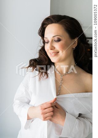 Close-up woman wears massive chain on neck, metal necklace. Modern jewellery concept Close-up woman wears massive chain on neck, metal necklace. Modern jewellery concept 109005372