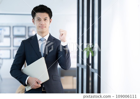 Handsome young businessman posing with a computer 109006111