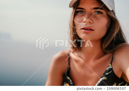 Woman travel sea. Happy tourist taking picture outdoors for memories. Woman traveler looks at the edge of the cliff on the sea bay of mountains, sharing travel adventure journey 109006597