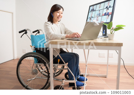 Woman in a wheelchair having a video call Woman in a wheelchair having a video call 109011003