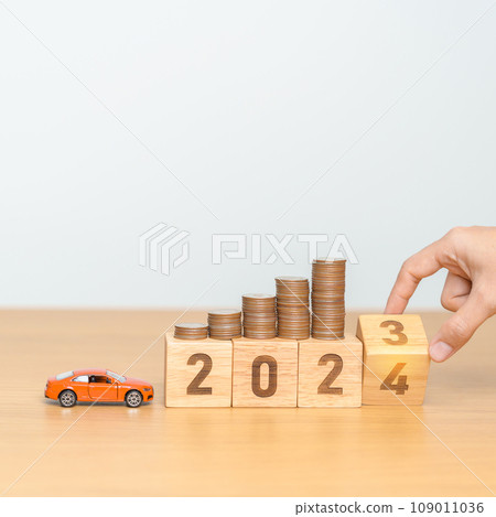 2023 flipping to 2024 year block with car model and Coins Money stack for deposit and Automobile Tax. Money Saving, Car Insurance, Financial, vehicle Repair and Maintenance and New Year concept 109011036
