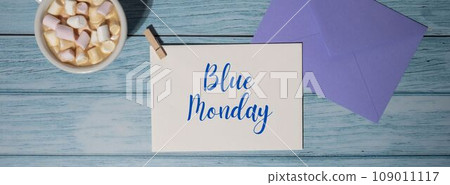BLUE MONDAY concept text violet envelope with white cup of coffee and marshmallows on wooden background. The most depressing day of the year in January. Day commit suicide and depression 109011117