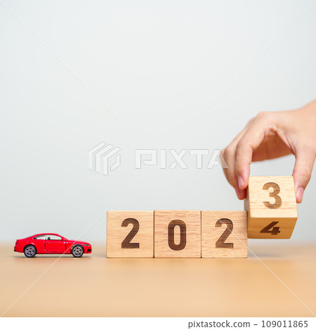 2023 flipping to 2024 year block with car model on table. Automobile Tax, Car Insurance, Financial, vehicle Repair and Maintenance and New Year concept 109011865
