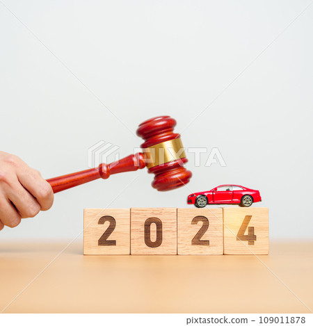 Car Law, Insurance, auto Tax, Auction and Bidding concepts. 2024 year block with crashed small toy car models with Judges gavel on desk in courthouse. 109011878