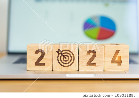 2024 Year block with dartboard icon against computer laptop background. Goal, Target, Resolution, strategy, plan, Action, mission, motivation, and New Year start concepts 109011893