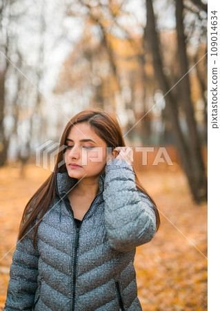 Beautiful indian woman generation z relaxing and feeling nature at autumn park in fall season copy space. Diversity and gen z youth Beautiful indian woman generation z relaxing and feeling nature at autumn park in fall season copy space. Diversity and gen z youth 109014634