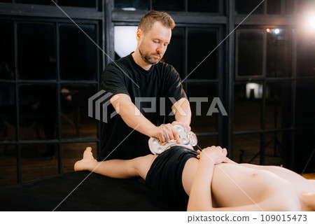 Massage with a special massage paddle, kneading trigger points in the abdomen, close-up. Blade massage. Side view. High quality photo Massage with a special massage paddle, kneading trigger points in the abdomen, close-up. Blade massage. Side view. High quality photo 109015473
