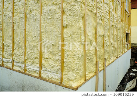 The facade of the residential house sprayed with a layer of polyurethane thermal insulation foam The facade of the residential house sprayed with a layer of polyurethane thermal insulation foam 109016239