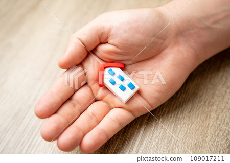 Save your home. Insurance agent protects the house with a gesture of protection. Security and safety in the home. Life insurance and family. Achieving peace of mind. Attention and care. 109017211