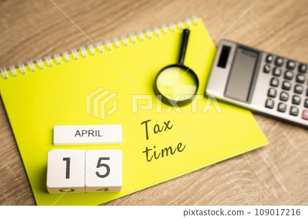 15 april - tax time concept. Taxpaying, business and finance. Notes, magnifying glass and calculator 15 april - tax time concept. Taxpaying, business and finance. Notes, magnifying glass and calculator 109017216