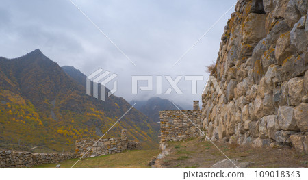 Seasonal autumn landscape in the Caucasus Mountains of Russia. Cloudy day with yellow trees and mountains behind. Popular travel destination in autumn Seasonal autumn landscape in the Caucasus Mountains of Russia. Cloudy day with yellow trees and mountains behind. Popular travel destination in autumn 109018343