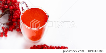 Hot viburnum tea in a glass cup with a double bottom on a white background. 109018486