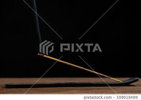 Lit smoking incense stick on black background. Aromatherapy Lit smoking incense stick on black background. Aromatherapy 109018499