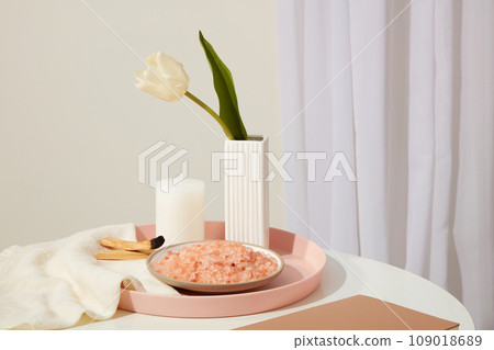 Pink tray in round shaped featured a flower pot, candle, palo santo wood smoke and a dish of pink himalayan salt. Himalayan salt can be used as cleansing water or toner to reduce acne 109018689