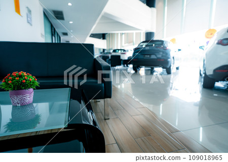 Blurred car parked in luxury showroom.  Car dealership office. New car parked in modern showroom. Automobile leasing and insurance background. Auto leasing business. Electric vehicle. Reception area. 109018965