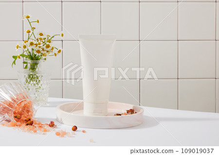Blank label tube in white color decorated with a pot of daisy flowers. Some people believe that pink Himalayan salt is lower in sodium than regular table salt Blank label tube in white color decorated with a pot of daisy flowers. Some people believe that pink Himalayan salt is lower in sodium than regular table salt 109019037
