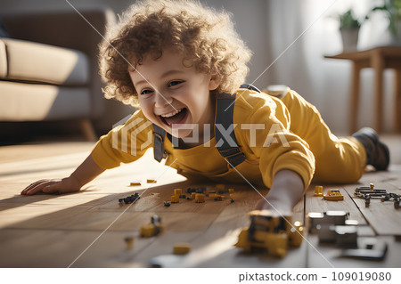 Happy child in yellow overalls with wavy hair plays with colorful toy blocks on the floor in a bright living room. Educational game for kids Happy child in yellow overalls with wavy hair plays with colorful toy blocks on the floor in a bright living room. Educational game for kids 109019080