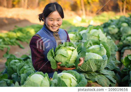 Smiling young Asian girl holding a large cabbage in vegetable farm. Generative AI Smiling young Asian girl holding a large cabbage in vegetable farm. Generative AI 109019656