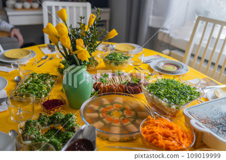 Easter family celebration. Traditional Polish dishes on a wooden table with yellow tablecloth Easter family celebration. Traditional Polish dishes on a wooden table with yellow tablecloth 109019999