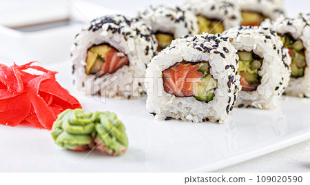 Sushi with salmon on a white plate with wasabi, ginger, soy, chopsticks on a white background Sushi with salmon on a white plate with wasabi, ginger, soy, chopsticks on a white background 109020590
