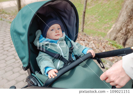 Surprised child in stroller in spring park Surprised child in stroller in spring park 109021151