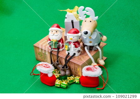 Table photo of miniature Santa, snowman, reindeer, boots and presents 109021299