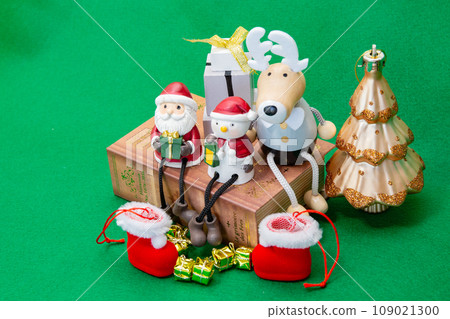 Table photo of miniature Santa, snowman, reindeer, boots and presents 109021300