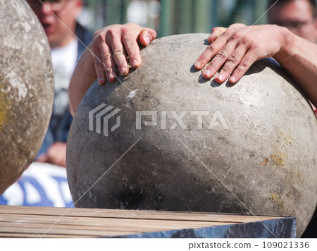 Muscular Man Lifting Heavy Concrete Ball Muscular Man Lifting Heavy Concrete Ball 109021336