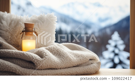 a fluffy blanket and a hot water bottle with a winter landscape in the background 109022417