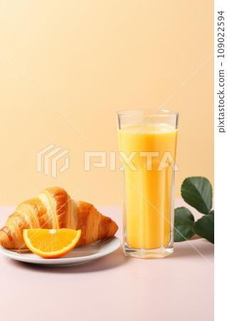 A glass of orange juice accompanied by a croissant with butter and jam 109022594