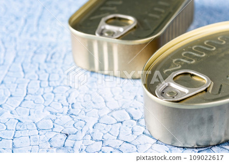 Canned food in metal can on blue background. 109022617
