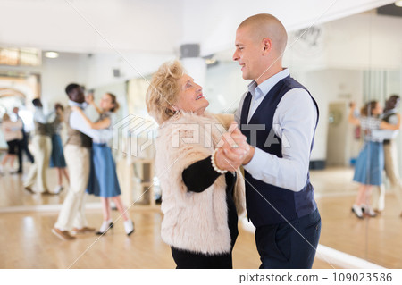 Man and mature woman learning to dance classical ballroom dance 109023586