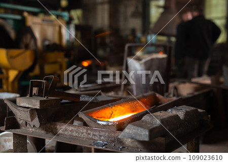 Mold with molten metal in the foundry workshop of metallurgical plant 109023610