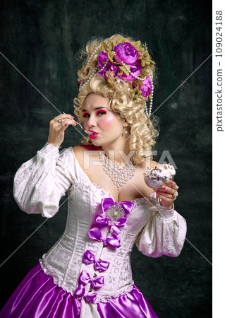 Beautiful woman, queen with bright make-up and retro hairstyle eating cold and sweet ice cream, tasty dessert against vintage background. 109024188